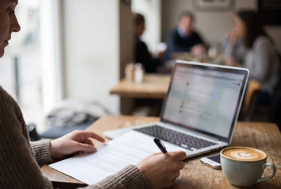Model reading a booking agreement on a laptop, her own rate and terms